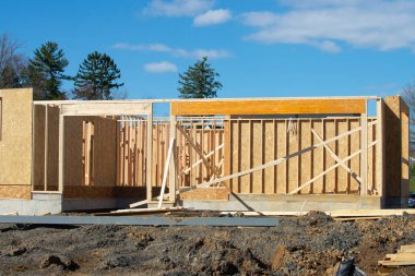 İnşaat kirişinin altındaki kontrplak bir evin iskeleti ahşap.