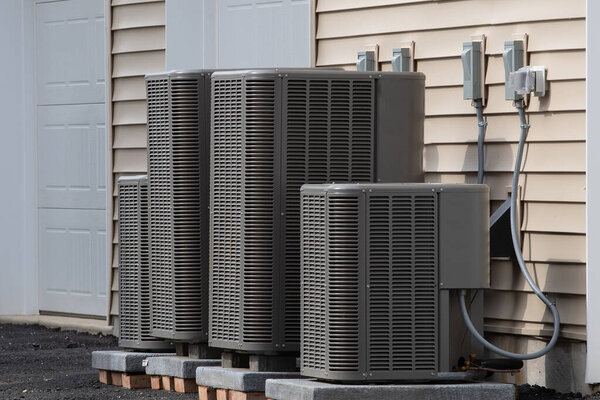 Heating and air conditioning outdoor unit in back of a house fan residental