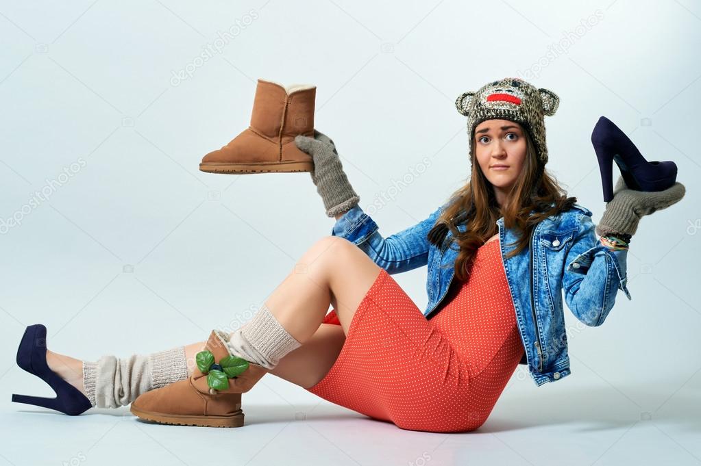 Young female holding a boot one hand and high heels another one