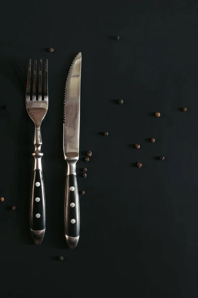 Una Forchetta Coltello Sfondo Nero Con Pepe Nero — Foto Stock