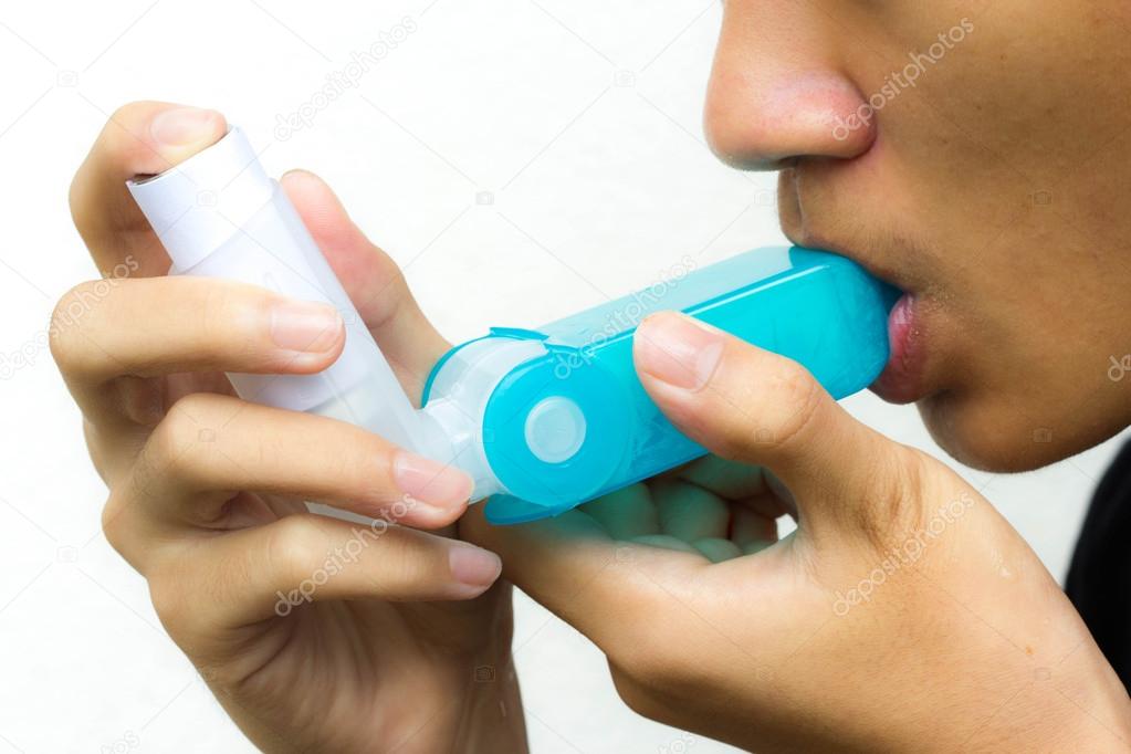 Man uses an inhaler an asthma attack