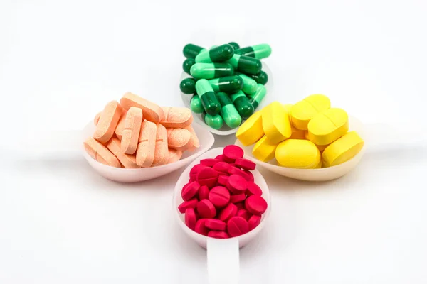 Pills in tea spoon on white background — Stock Photo, Image