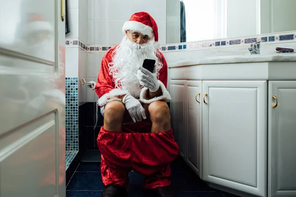 Święty Mikołaj Łazience Siedzi Klozecie Patrzy Komórkę — Zdjęcie stockowe