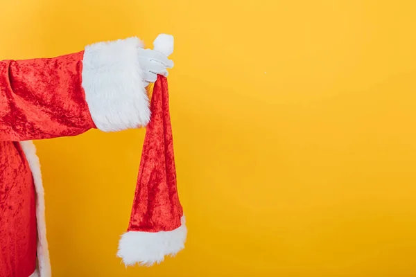 Braço Papai Noel Segurando Chapéu Fundo Amarelo Conceito Chistmas — Fotografia de Stock