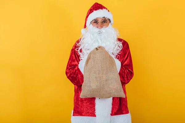 Papai Noel Segurando Saco Fundo Amarelo Conceito Natal — Fotografia de Stock