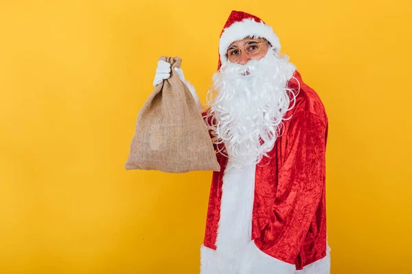 Papai Noel Segurando Saco Fundo Amarelo Conceito Natal — Fotografia de Stock