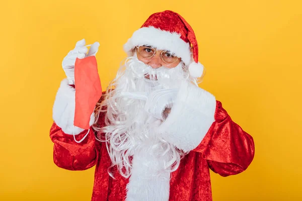 Papai Noel Segurando Uma Máscara Vermelha Fundo Amarelo Conceito Natal — Fotografia de Stock