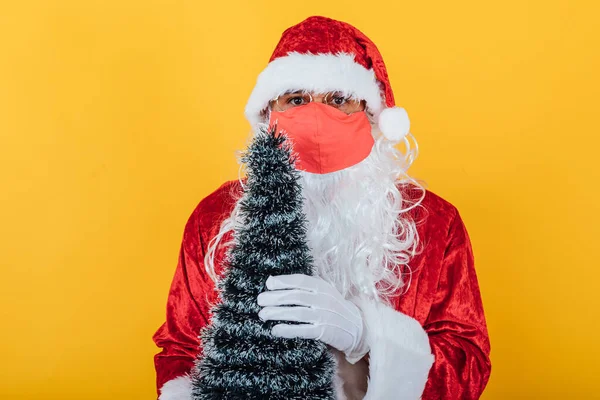 Der Weihnachtsmann Trägt Eine Rote Gesichtsmaske Und Hält Einen Weihnachtsbaum — Stockfoto