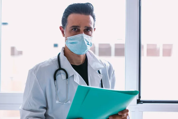 Dokter Mengenakan Masker Bedah Mantel Putih Stetoskop Dan Folder Biru — Stok Foto