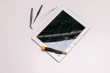 Aletler ve kırık camlı bir tablet. Teknoloji bakım konsepti