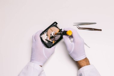 Eldivenli bir teknisyenin elleri sabit diski tamir ediyor. Teknoloji bakım konsepti