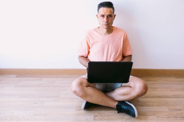 Adamın biri laptopuyla yerde oturuyor ve evden evden eve gidiyor.