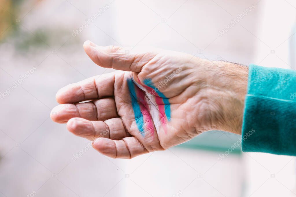 Transsexual man shows his hand with painted transsexual flag