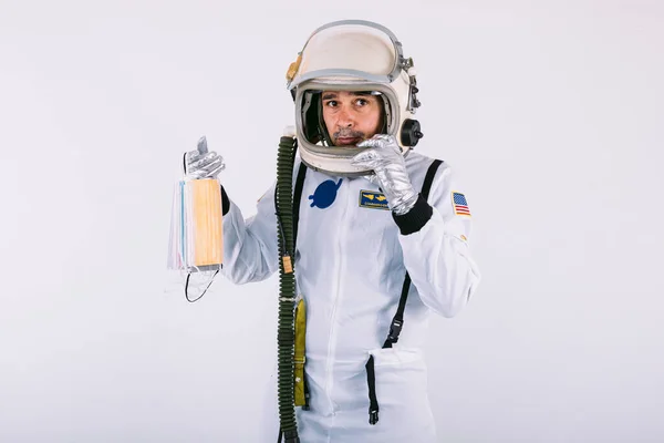 Mężczyzna Kosmonauta Skafandrze Kasku Trzymając Wiele Kolorowych Masek Chirurgicznych Kształcie — Zdjęcie stockowe