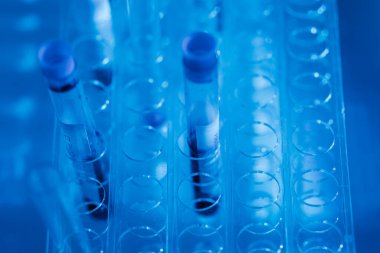 Laboratuvar masasında mavi ışık ortamına sahip test tüplerinin ayrıntıları