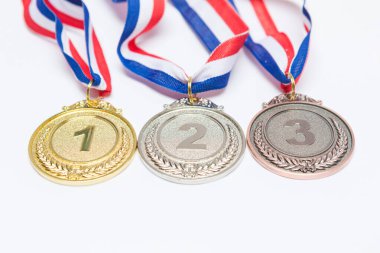 Beyaz arka planda birinci, ikinci ve üçüncü olmak üzere altın, gümüş ve bronz spor madalyaları. Olimpiyat oyunları ve spor konsepti.