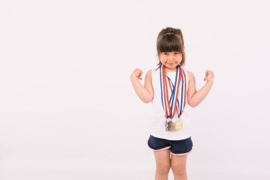 Boynunda spor şampiyonluğu madalyası olan kahverengi saçlı küçük bir kız. Gücün sembolünü oluşturuyor. Spor ve zafer kavramı