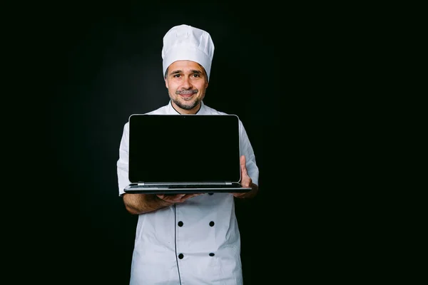 Cozinheiro Chef Vestindo Jaqueta Cozinha Chapéu Segurando Laptop Mostrando Sua — Fotografia de Stock