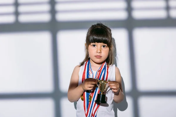 Dunkelhaariges Mädchen Mit Sportmedaillen Und Pokalen Das Schatten Eines Fensters — Stockfoto