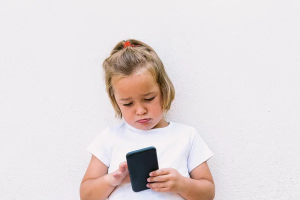 Menina Cabelo Loiro Vestindo Shirt Branca Olhando Para Telefone Móvel — Fotografia de Stock