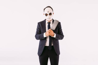 Takım elbiseli ve kravatlı bir adam Cadılar Bayramı 'nda alnında haç olan katil maskesi takıyor ve bıçakla tehdit ediyor. Karnaval ve Cadılar Bayramı kutlaması