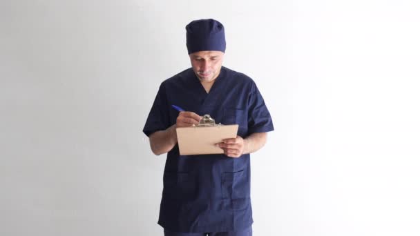 男护士 男医生或穿着蓝色制服的兽医在医院的窗口 拿着装有报告和微笑的文件夹 医院和保健概念 — 图库视频影像
