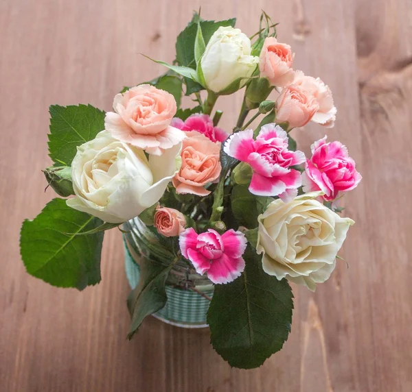 バラと木製のテーブルのカーネーションの花束 — ストック写真