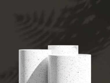 Yumuşak kıvrımlı granit podyum üçlüsü soluk gölgeli soluk gri bir duvarın karşısında.