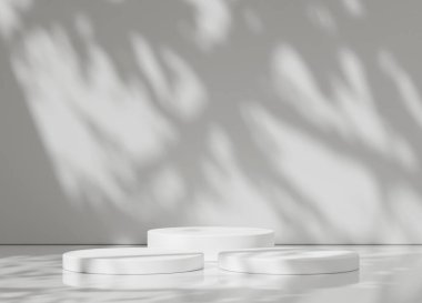 Sıraya dizilmiş üç beyaz podyum var. Doğal gölgeler tasarımın basitliğini arttırıyor..