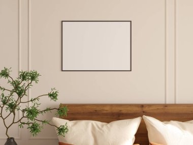 Yatak odasının duvarında asılı kare fotoğraf çerçevesi, tahta yatak ve doğal yeşil bitki..