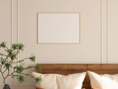 Yatak odasının bej duvarında dekoratif bitki ve yastıklarla çerçevelenmiş boş fotoğraf modeli..