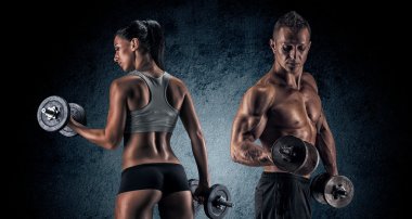 Athletic man and woman with a dumbells.