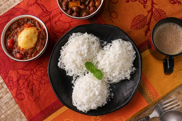 Noolappam, idiyappam pirinç eriştesi buharda pişmiş Kerala kahvaltı baharatlı baharatlı körili hindistan cevizi sütü killi tabakta Tamil Nadu Hindistan Güney Hindistan noolputtu Sri lanka yemeği
