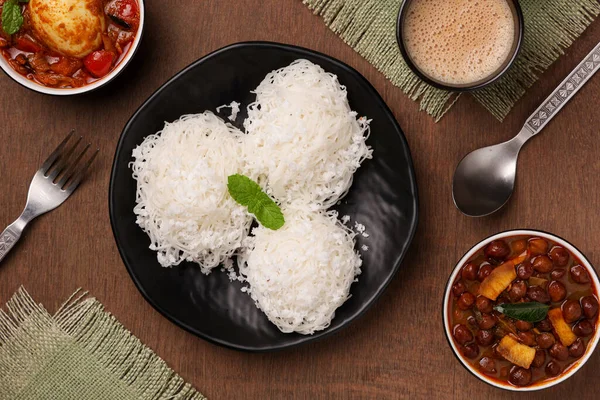 Noolappam, idiyappam pirinç eriştesi buharda pişmiş Kerala kahvaltı baharatlı baharatlı körili hindistan cevizi sütü killi tabakta Tamil Nadu Hindistan Güney Hindistan noolputtu Sri lanka yemeği
