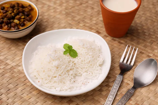 Noolappam, idiyappam pirinç eriştesi buharda pişmiş Kerala kahvaltı baharatlı baharatlı körili hindistan cevizi sütü killi tabakta Tamil Nadu Hindistan Güney Hindistan noolputtu Sri lanka yemeği