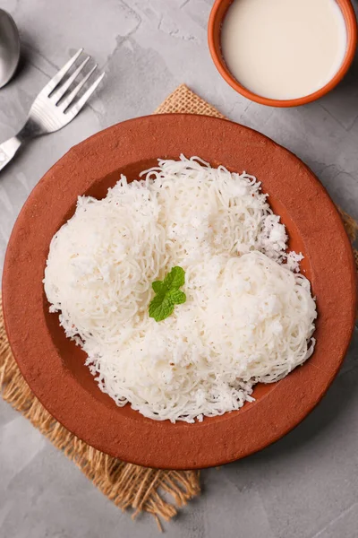 Noolappam, idiyappam pirinç eriştesi buharda pişmiş Kerala kahvaltı baharatlı baharatlı körili hindistan cevizi sütü killi tabakta Tamil Nadu Hindistan Güney Hindistan noolputtu Sri lanka yemeği