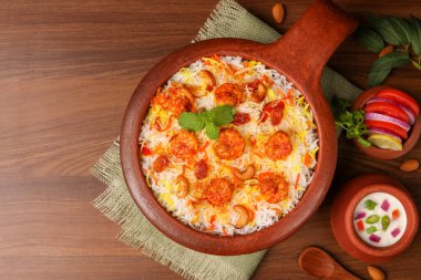 Karides ya da karides biryani, balık biryani. Baharatlı ve lezzetli Malabar biryani veya Hydrabadi biryani, Dum Biryani, pulao basmati pilavı, otlar, Ramazan Kareem için raitha. Hint yemeği.