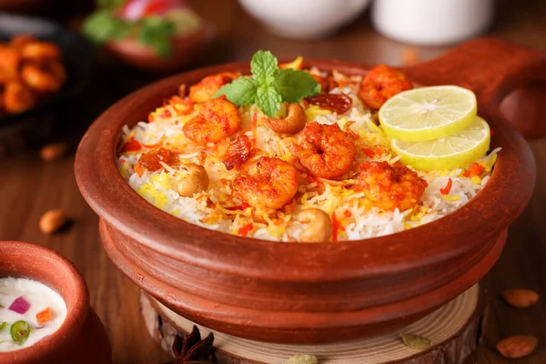 Karides ya da karides biryani, balık biryani. Baharatlı ve lezzetli Malabar biryani veya Hydrabadi biryani, Dum Biryani, pulao basmati pilavı, otlar, Ramazan Kareem için raitha. Hint yemeği.
