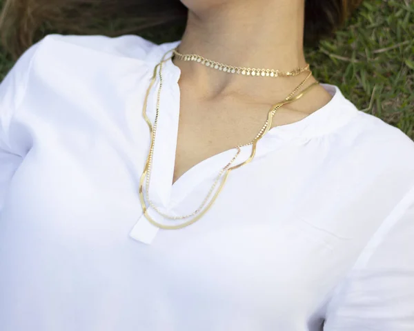 Woman wearing gold necklace.  Necklace at the neck of young woman, women\'s accessories, gold necklace