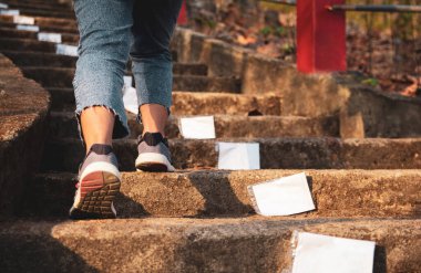 Yeni yıla başla. Merdivenlerden gün batımına kadar kadının yürümeye başlaması. Başarının amacı.