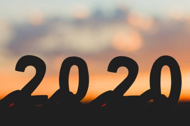 Siluet 2020 Mutlu Yeni Yıl 'lar gökyüzünde ahşap numaralar ve bulutların alacakaranlığı güzel doğa arkaplanı.
