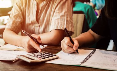 Öğrenci oturmuş, ders çalışıyor. Arkadaşlarıyla ders kitapları okuyor. Genç öğrenciler kampüsü, arkadaşa, arayı kapatmada ve öğrenmede yardımcı oluyor. Eğitim öğrenen insanlar