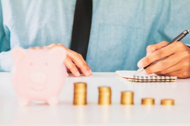 İşadamı kağıt yazıyor ve üretkenliği artırmak için çalışanlarına hesap makinesi primi (veya başka bir tazminat) kullanıyor. masaseçmeli Odaklanma