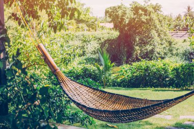 Bambu beşiği bahçede ve arka planda rahatlar.