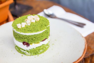 Kremalı ve ahşap masadaki kırmızı fasulyeli kibrit yeşili kek fırını..