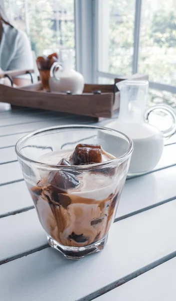 coffee with ice on the cup on the wooden table Cold drinks in the summer.