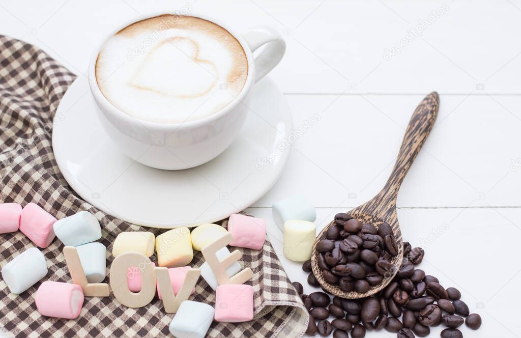 Coffee cup white hart latte art and dessert of marshmallow, Roasted coffee beans on white wooden.Copy space for you text