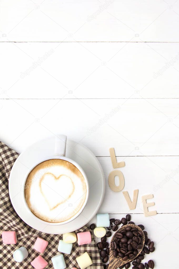 Coffee cup white hart latte art and dessert of marshmallow, Roasted coffee beans on white wooden,Copy space for you text.vertical