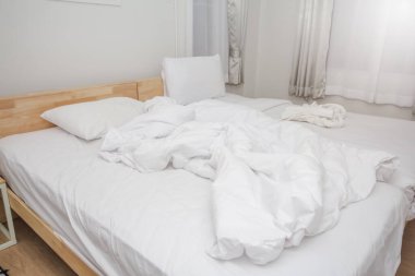 Oda temiz beyaz yastıklar ve güzel çarşaflar ve ev mobilyaları güneş ışığı ile iç içe..