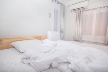 Oda temiz beyaz yastıklar ve güzel çarşaflar ve ev mobilyaları güneş ışığı ile iç içe..